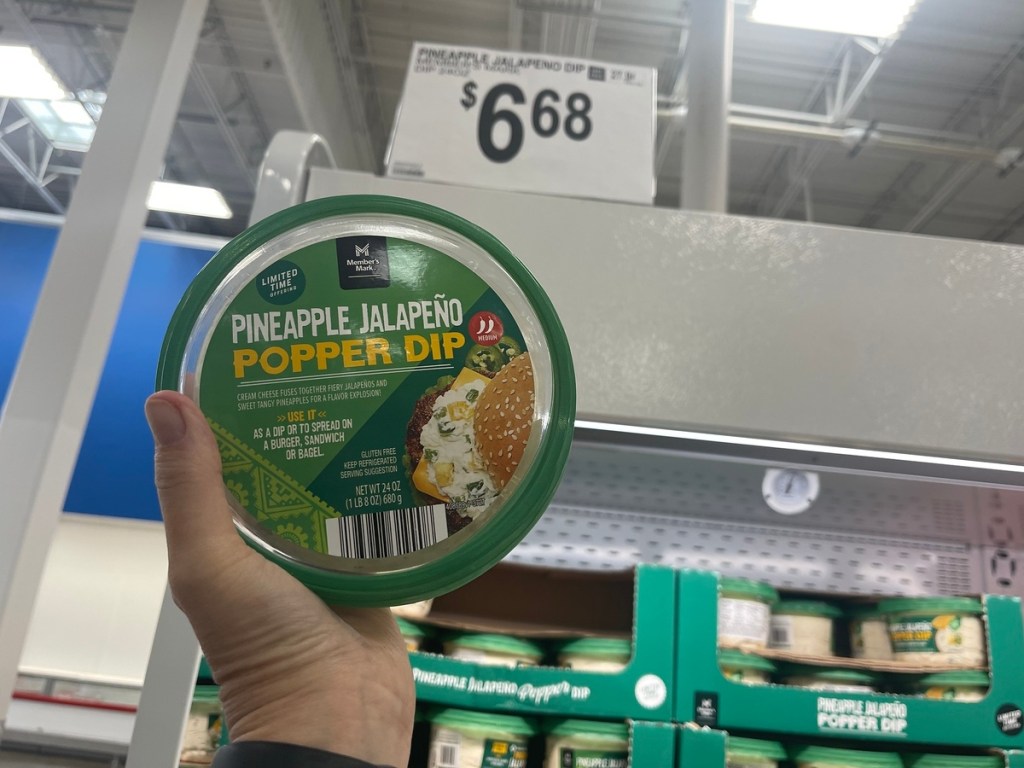 holding a tub of dip at Sam's Club