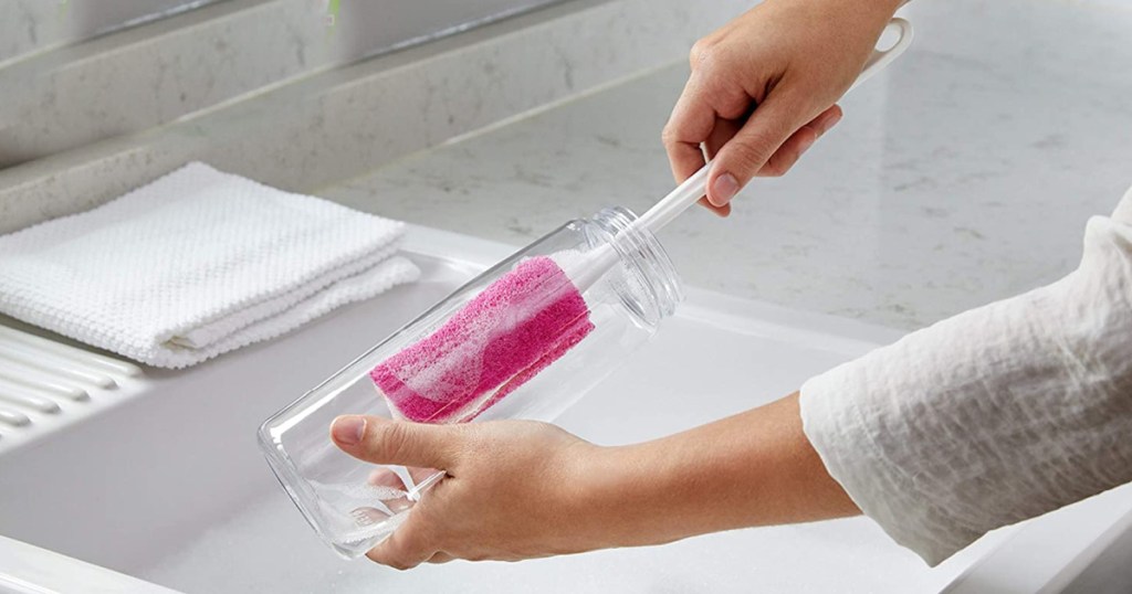 hand putting pink brush in bottle
