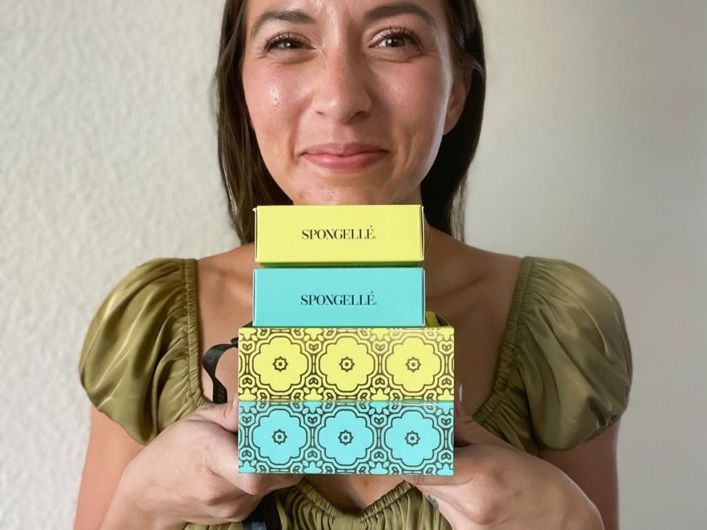 woman holding a stack of Spongelle sponges