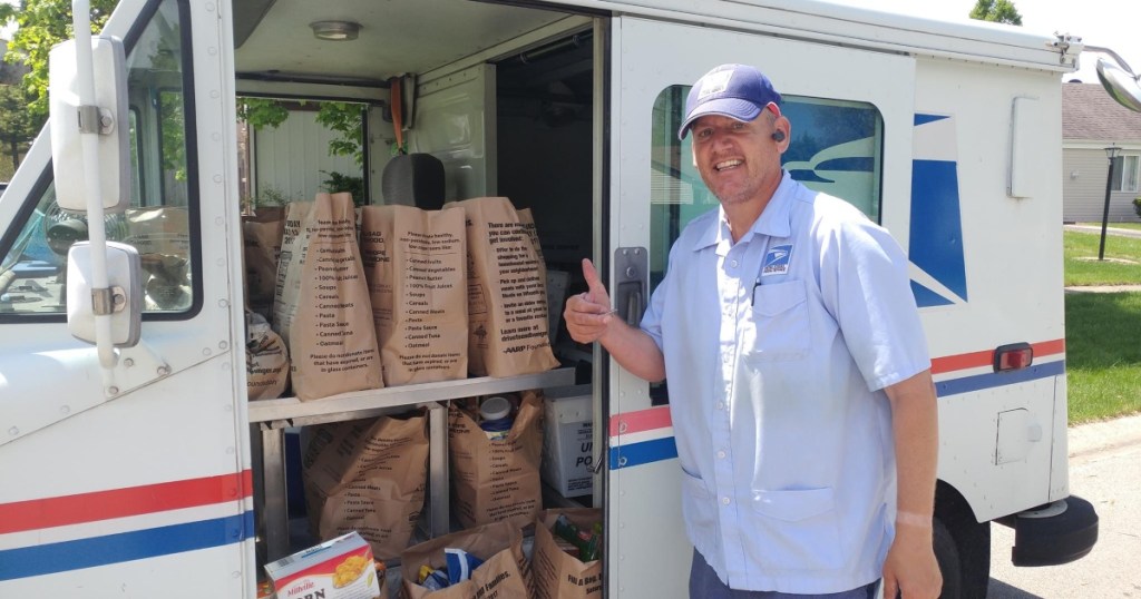 postal worker collecting food donations in mail truck