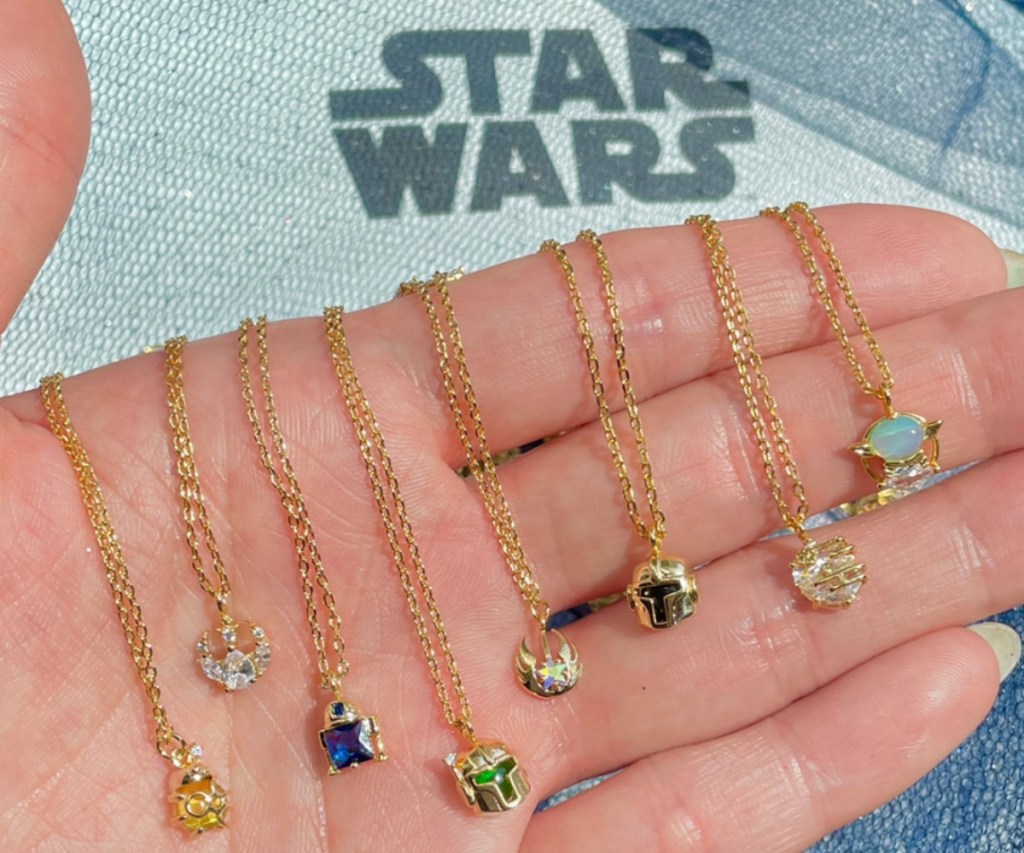 hand holding Star Wars necklaces
