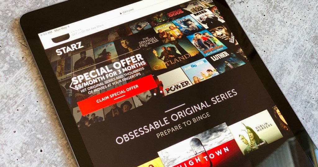 holding a tablet open to Starz app