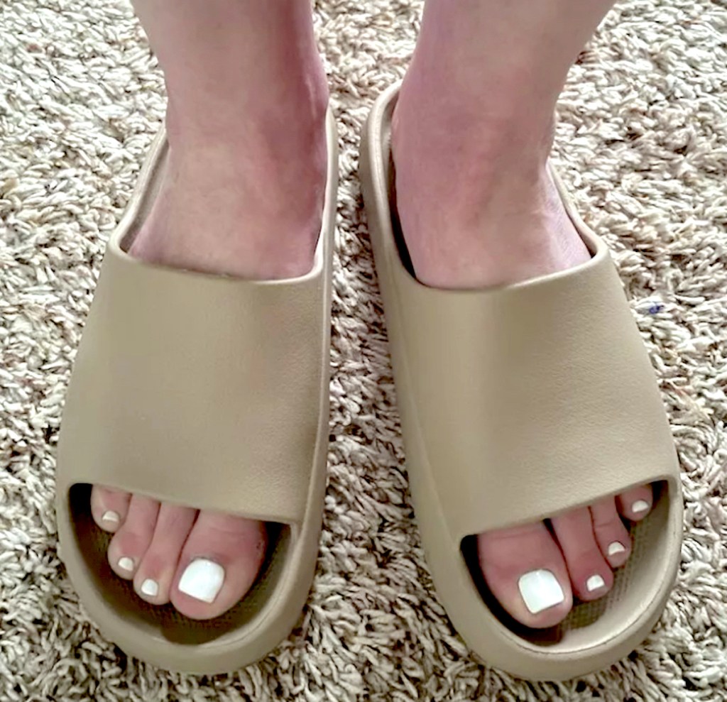 close up of feet wearing brown slides target sandals