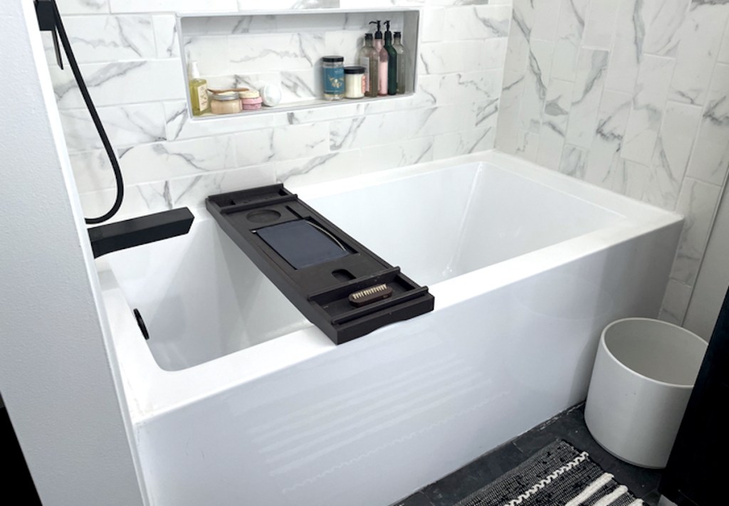 white bathtub with wood tray
