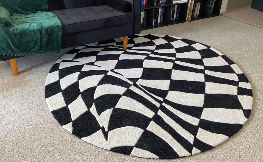 black and white geometric rug on carpet floor with couch
