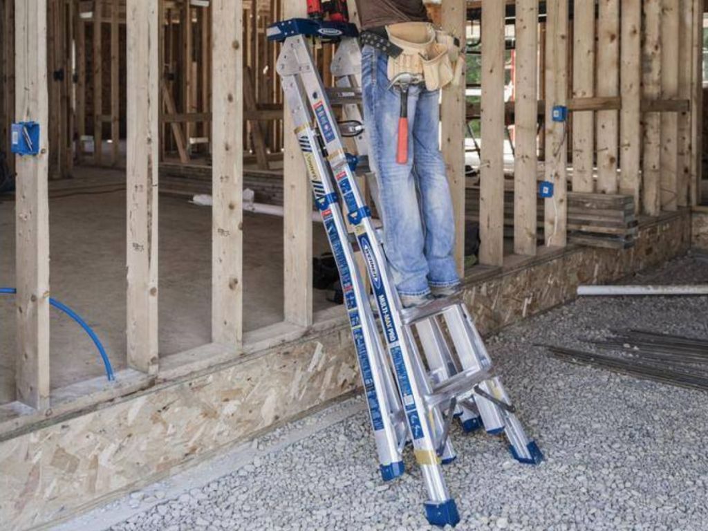 man standing on Werner ladder at construction site