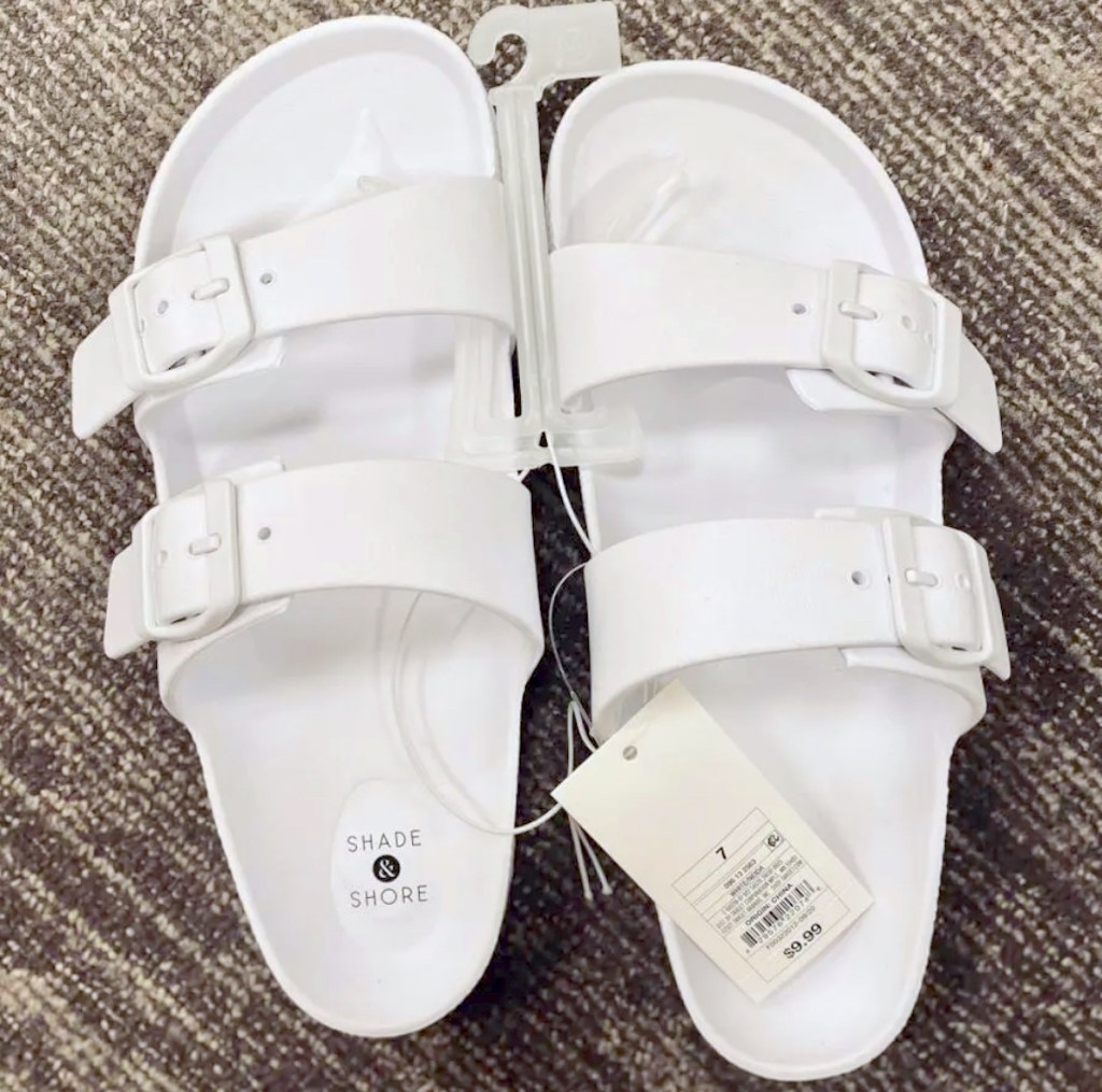white slides with store price tag sitting on floor
