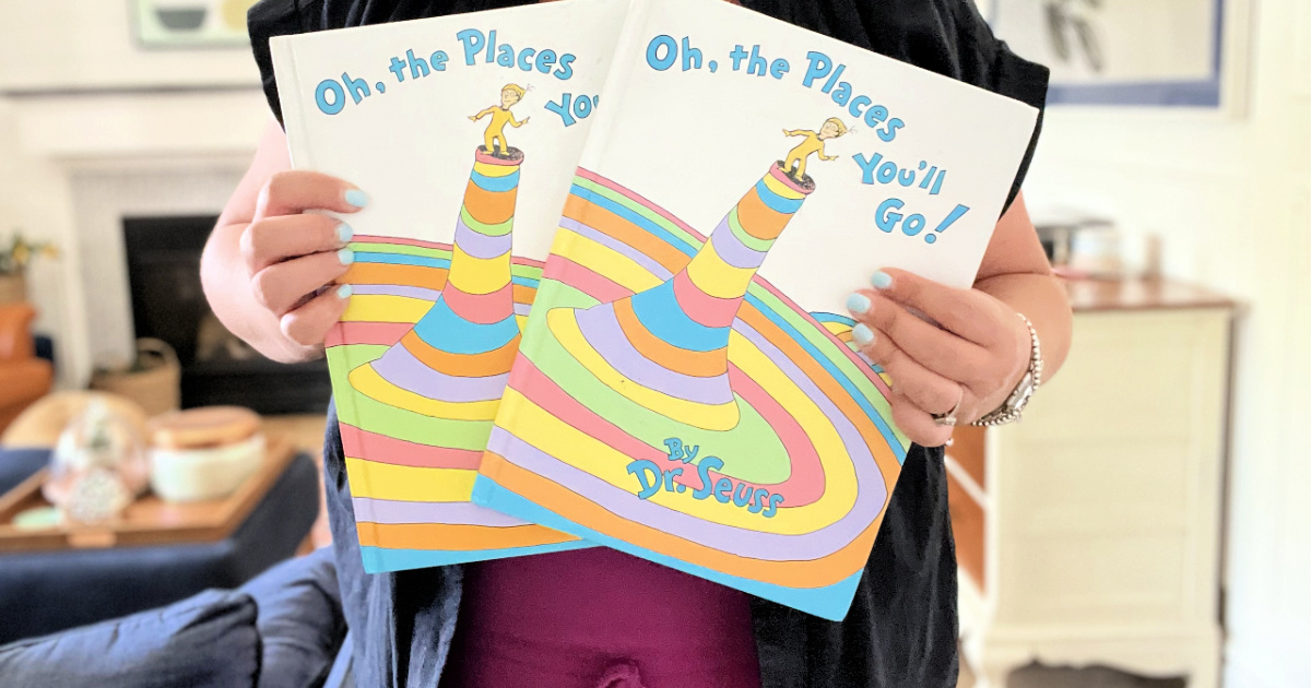woman holding 2 copies of oh the places you will go book