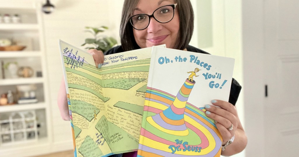 woman holding two copies of oh the places you'll go