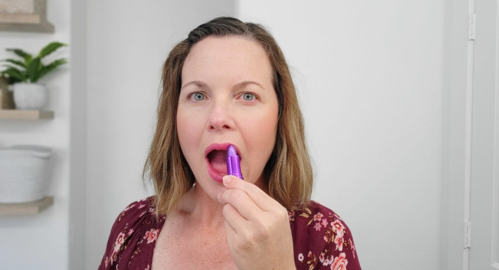woman applying purple lip balm