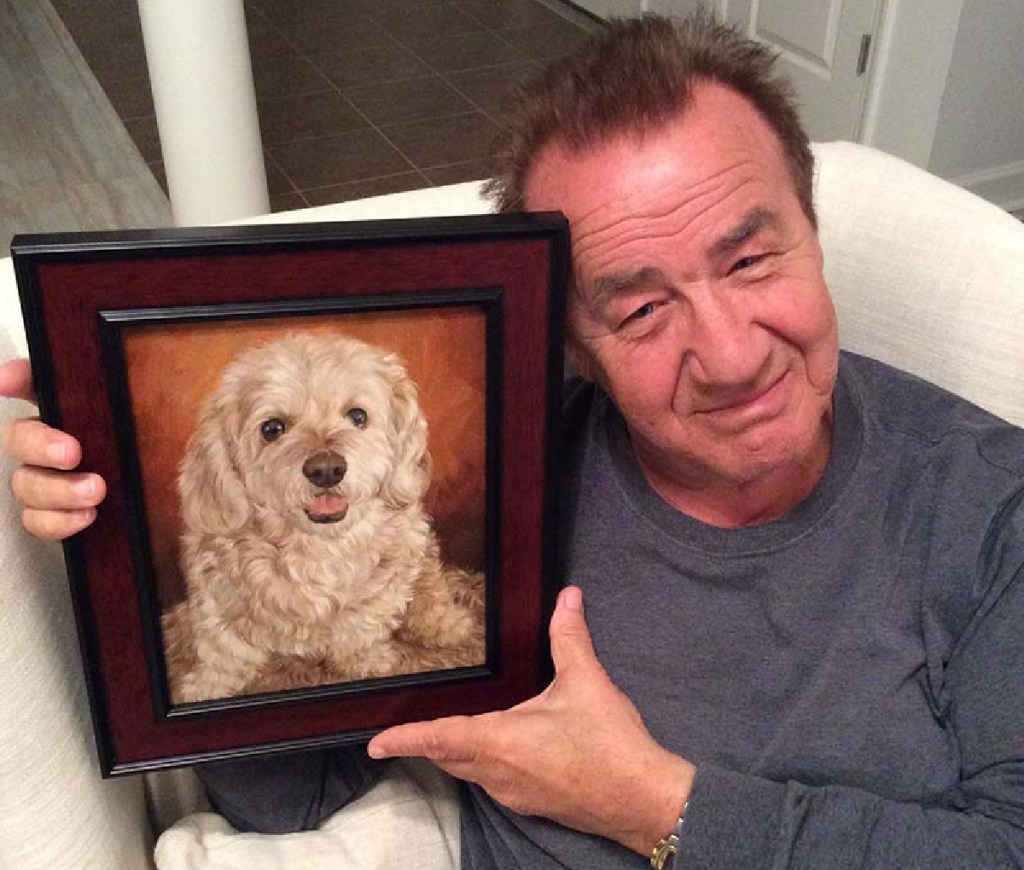 Man holding a portrait of his dog from paint your life pet portraits