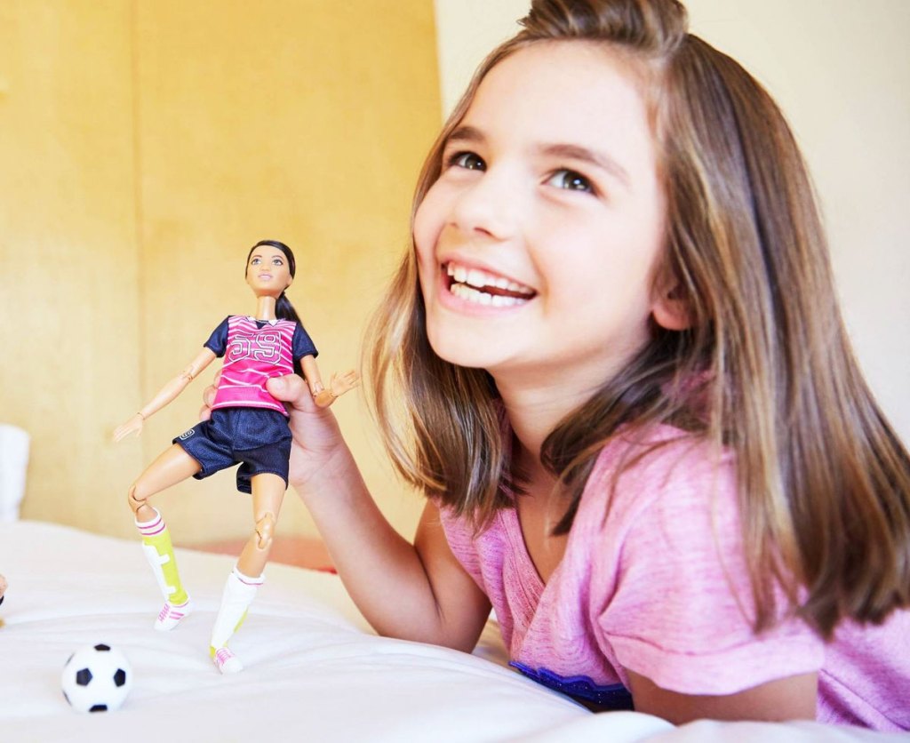 girl playing with Barbie Made to Move Soccer Player Doll