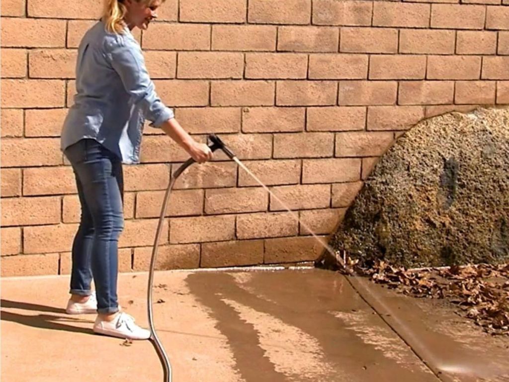 woman using hose on patio