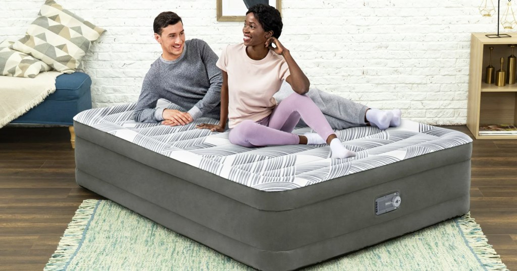 two people sitting on top of an air mattress