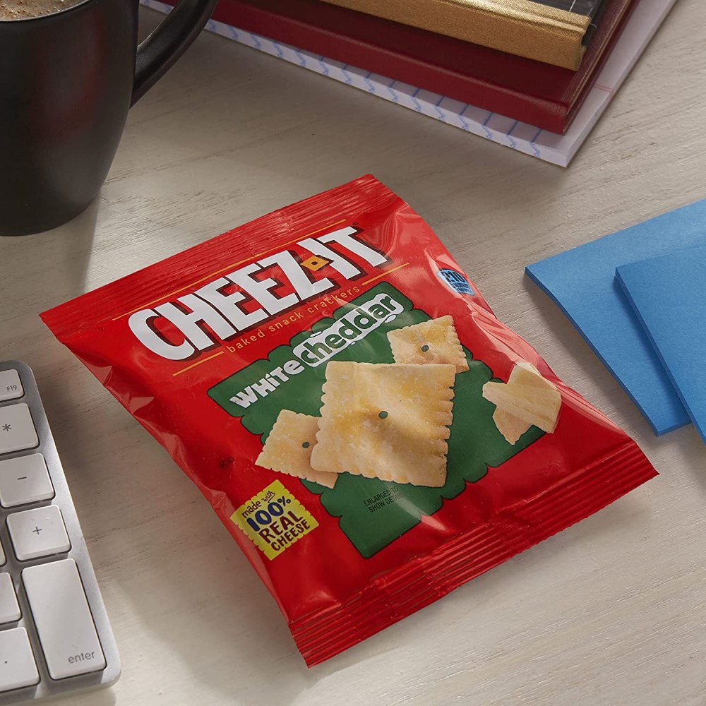 Cheez It White Cheddar on desk next to books and supplies