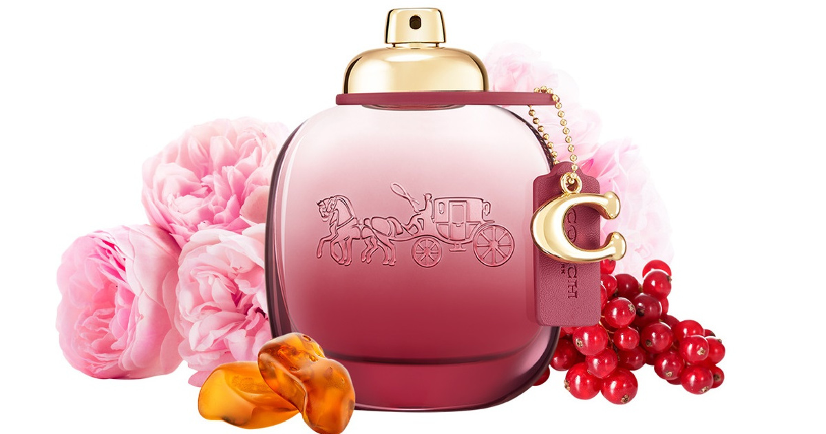 Coach Wild Rose Perfume bottle with flowers around it.