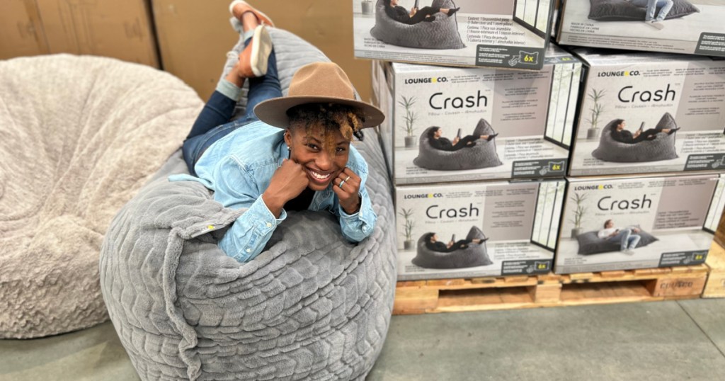 person wearing hat and laying on oversized pillow in Costco