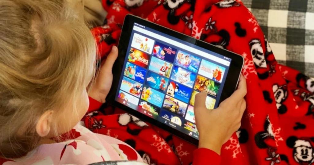 little girl looking through Disney movies on iPad 