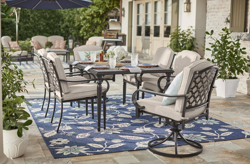 Dining set on a patio with a blue rug underneath it