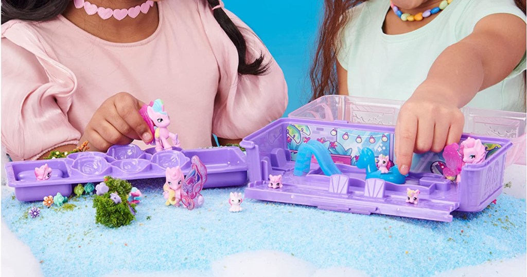 two girls playing with pony playset