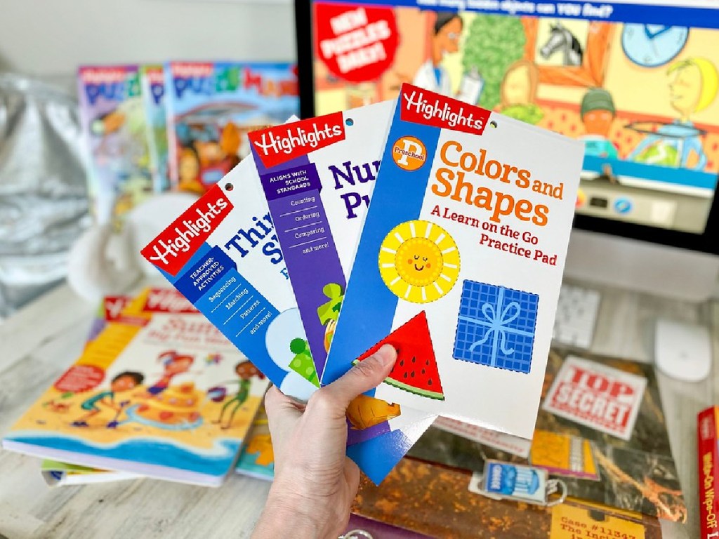 hand holding various highlights magazines