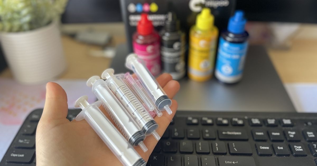 hand holding Hipoo Sublimation Ink Refills syringes