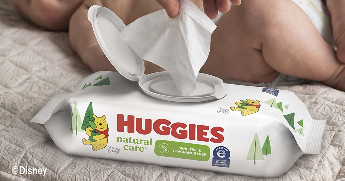 person pulling out wipe from flip top container of Huggies Natural Care Wipes