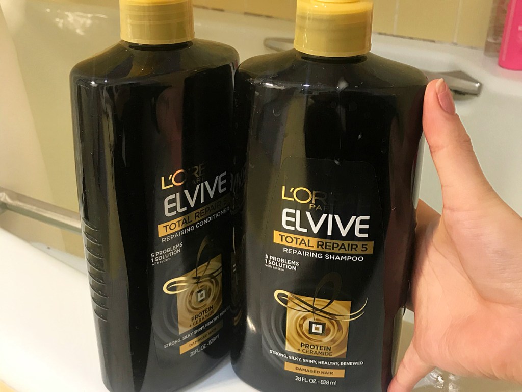 two large bottles of shampoo and conditioner on shower ledge