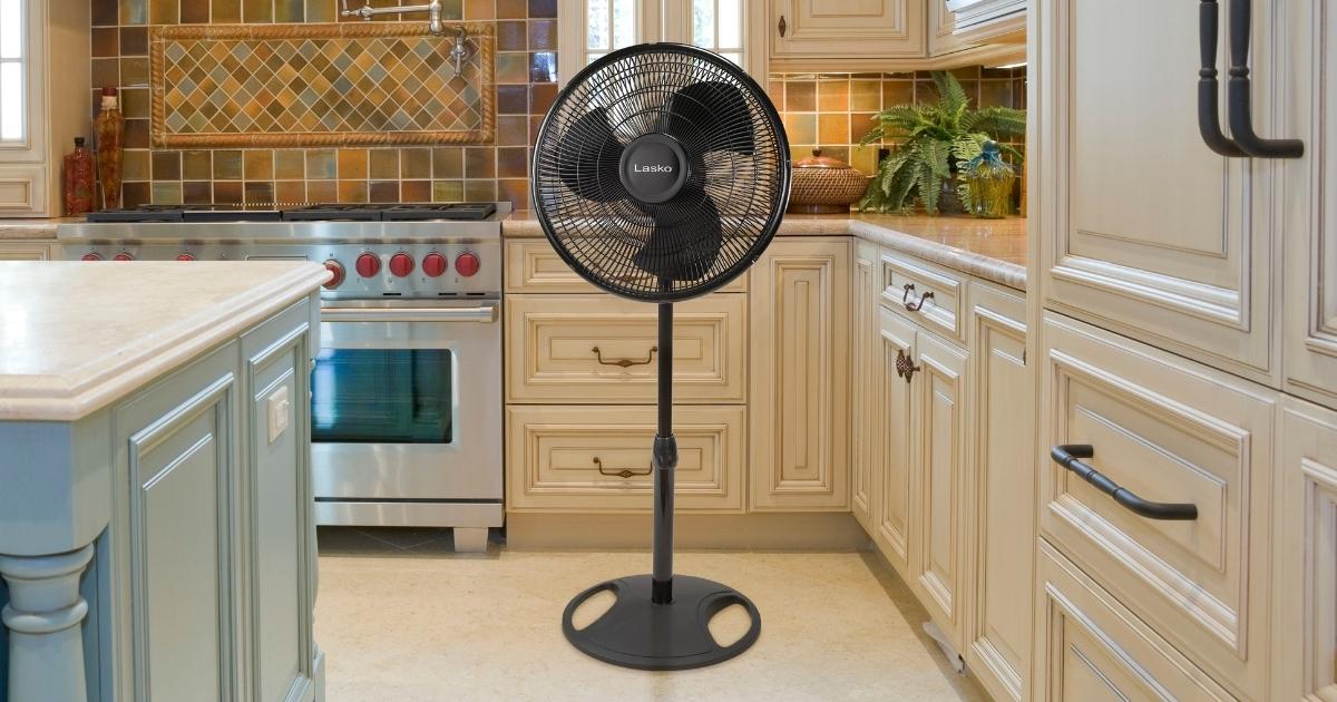 lasko fan standing on the floor in the middle of a higher end kitchen with center island 