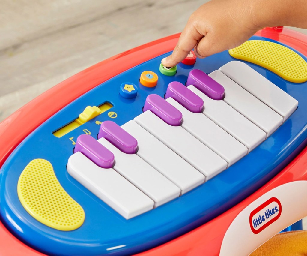 child pushing keys on interactive sing-along piano
