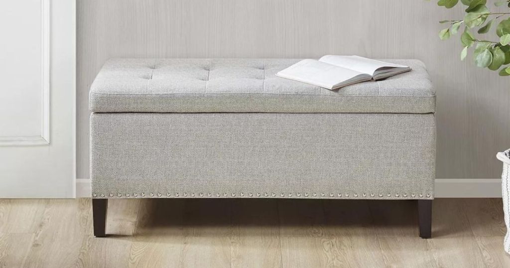 Storage ottoman with a book laying on the top