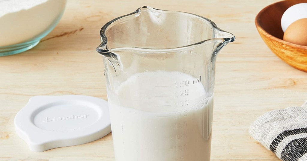 Measuring cup filled with milk on counter