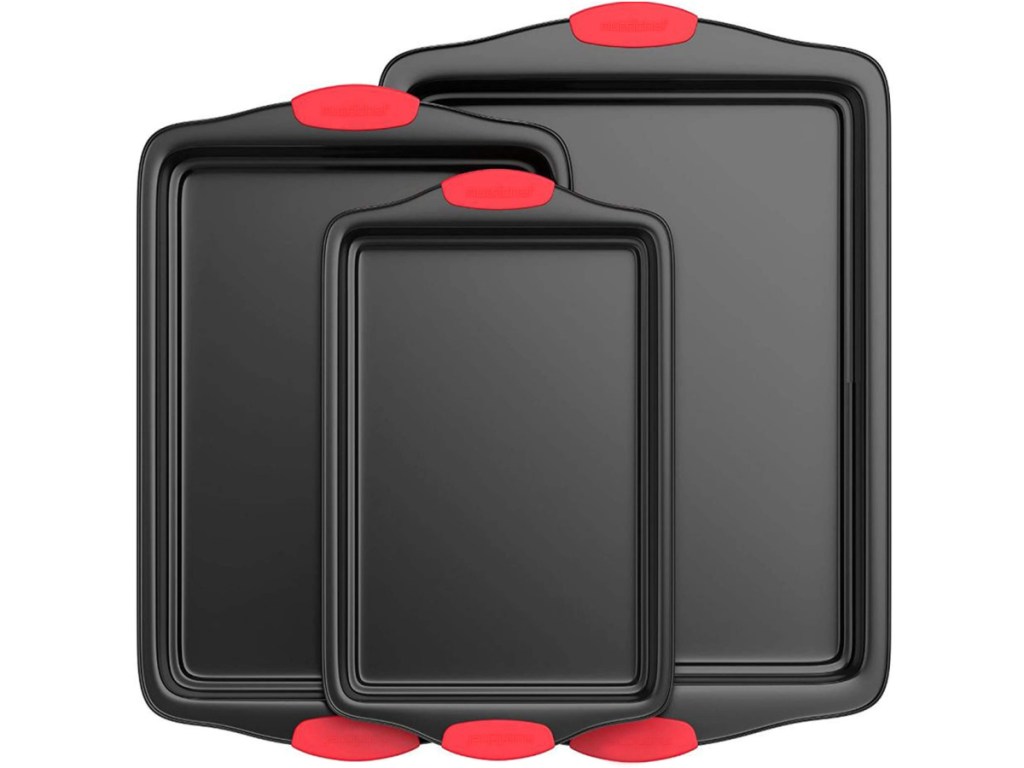 three black cookie sheets with red silicone handles