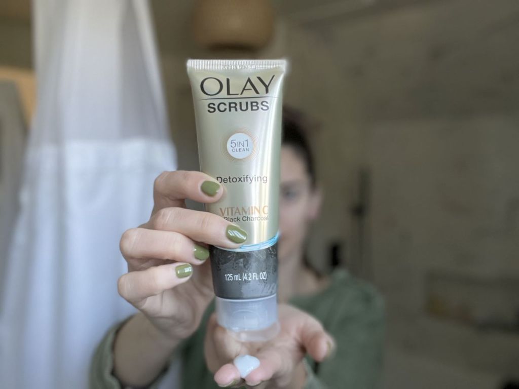 woman holding an Olay Charcoal Scrub