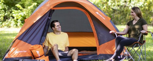 two people with orange camping tent and gear