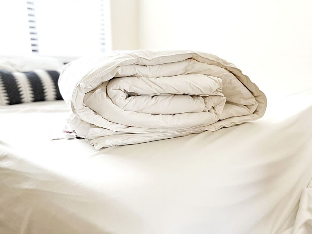 white down comforter folded on bed