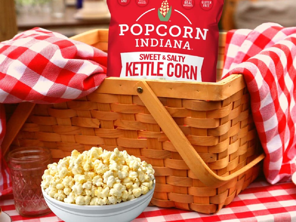 Popcorn bag in picnic basket with popcorn in a bowl