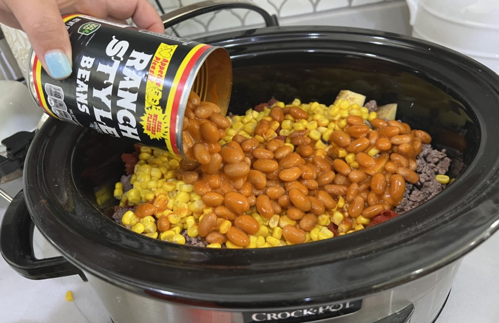 Pouring ranch style beans into a slow cooker