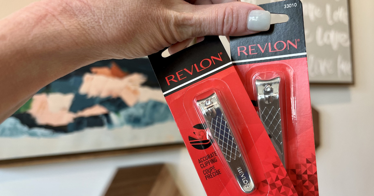 Hand holding two packages of Revlon Clippers