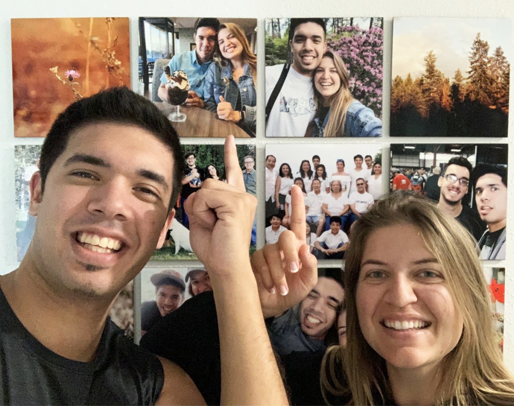 couple pointing to their photo gallery wall