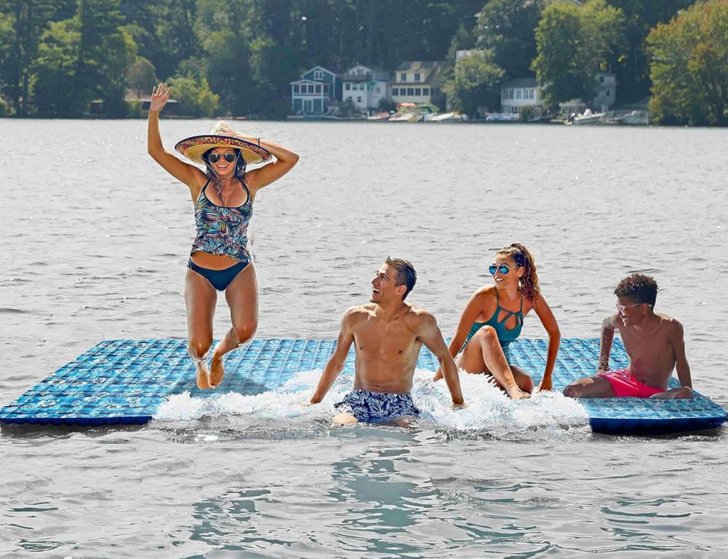 Adults playing and lounging on an inflatable mat
