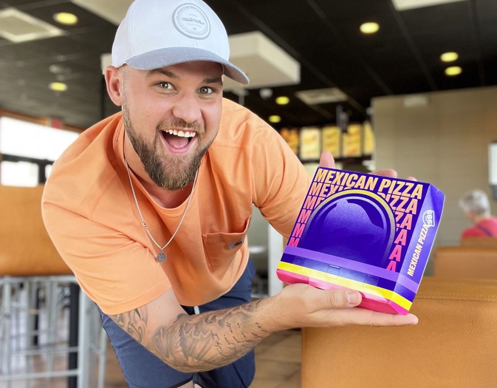 man holding taco bell mexican pizza box
