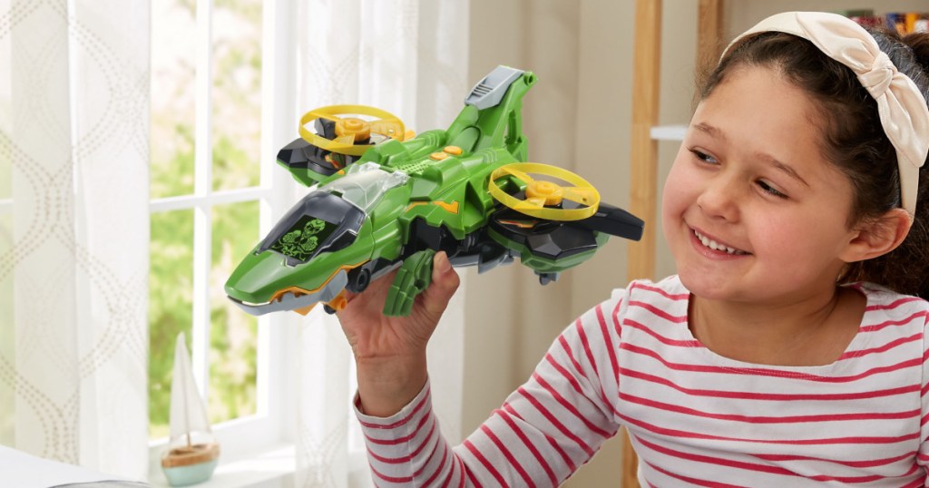 girl playing with dinosaur jet vehicle in bedroom