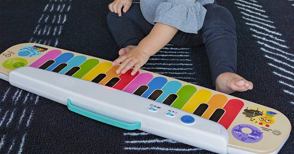 child playing with baby Einstein wooden keyboard