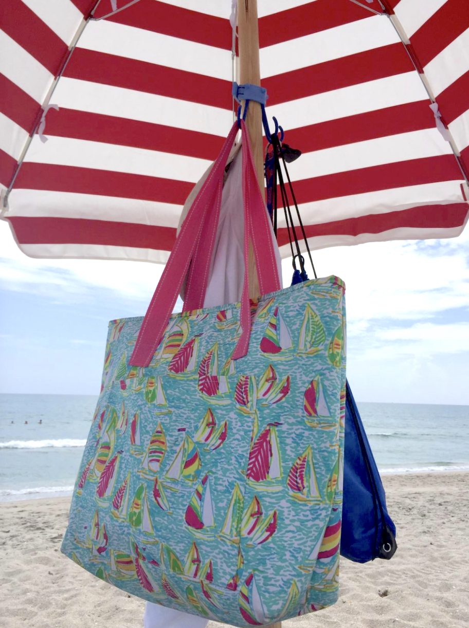 red and white stripe umbrella with hooks and bags hanging from them
