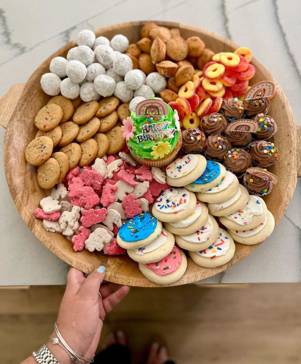 hand holding a tray with sweet treats on it