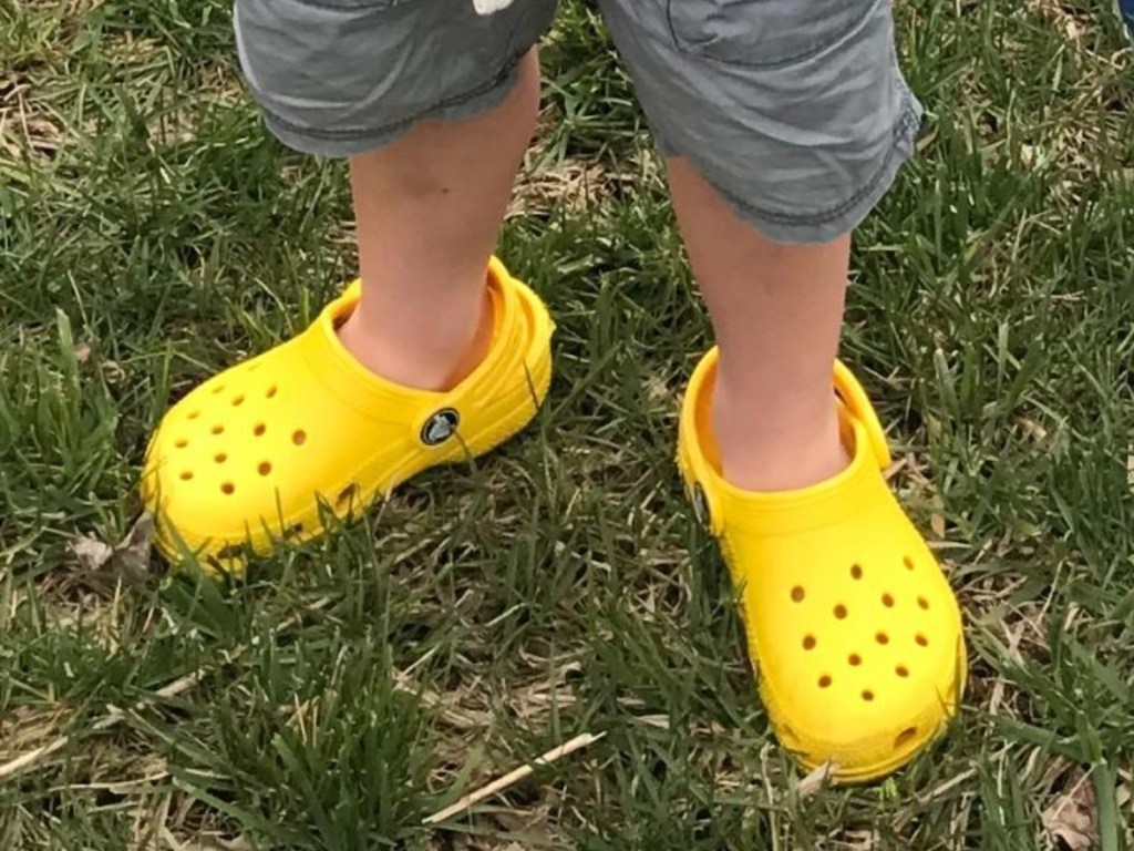 boy wearing yellow Crocs in grass