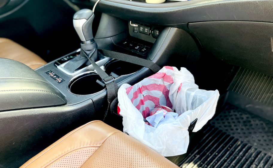 trash can in car with can and paper inside