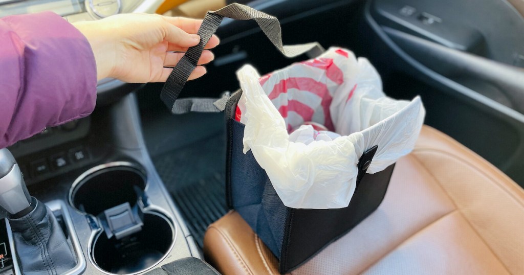 hand holding black car trash can with target shopping bag inside