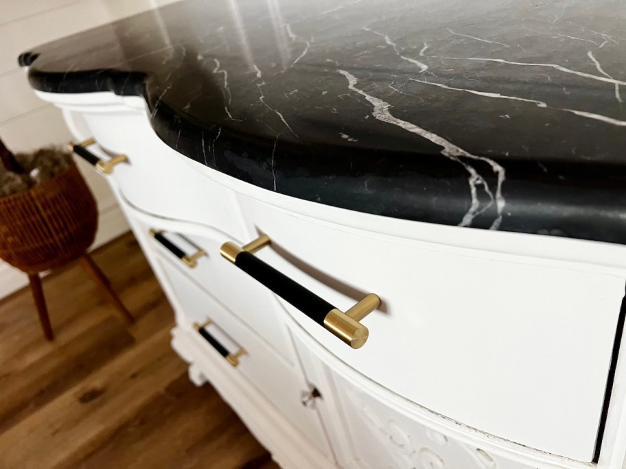 close up of white chalk paint furniture with black and gold modern handles